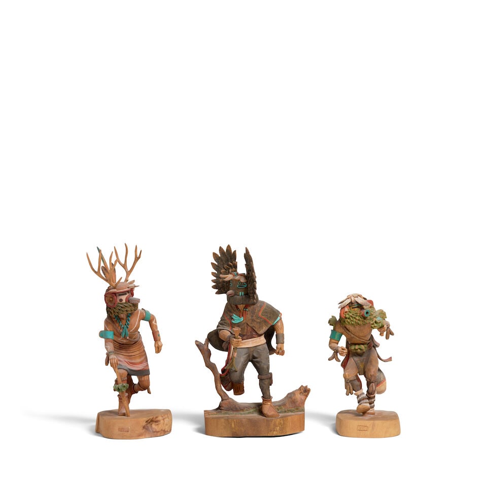 Three Dennis Tewa katsina carvings: Dennis Tewa Hopi, (1945-2013), three katsina figures, carved and painted wood, including a Deer Dancer, Owl, and a Rugan or Rasp katsina, each on an integral wood base, signed 'DTEWA'; the Deer Dancer