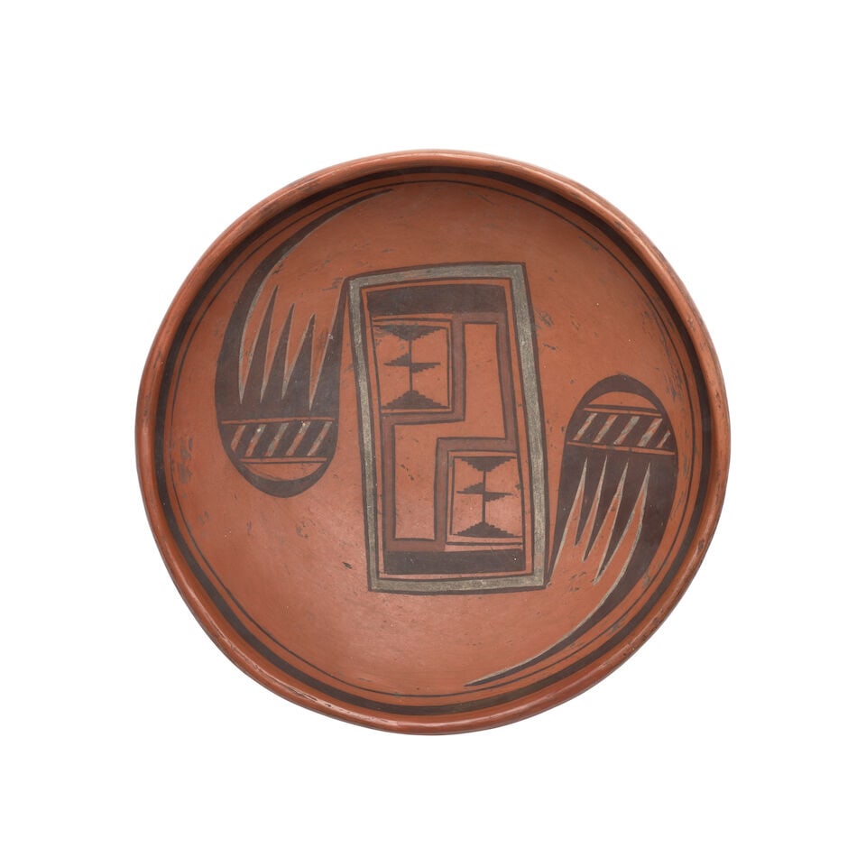 A Hopi redware bowl, possibly the work of Nampeyo: A Hopi redware bowl Possibly the work of Nampeyo, (1859-1942), the interior painted aligning a pair of migration motifs around a central rectangular box with stepped elements, banding below the