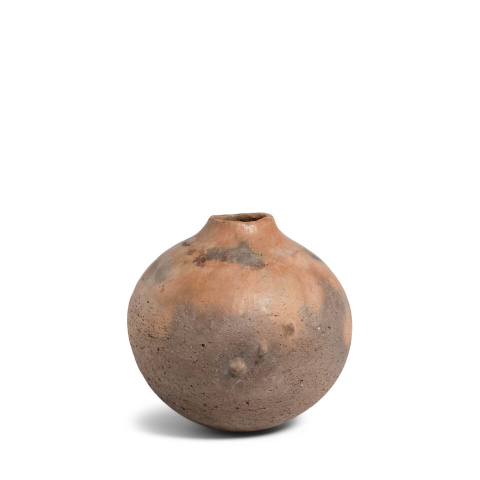 A Rick Dillingham buffware pottery jar: Rick Dillingham American, (1952-1993), 1974, a buffware pottery jar, of spherical form with a few asymmetrical bumps raised above the surface, in natural clay colors with fireclouds for effect, signed