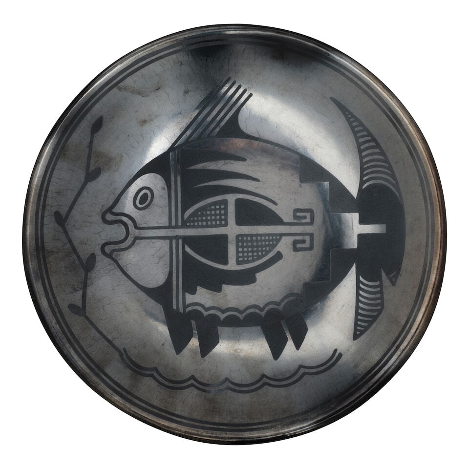A Maria Martinez and Popovi Da pictorial plate: Maria Martinez and Popovi Da San Ildefonso, (1887-1980) and (1923-1971), dated 9.64, depicting a fish, water plants and waves against a highly polished gunmetal surface, signed