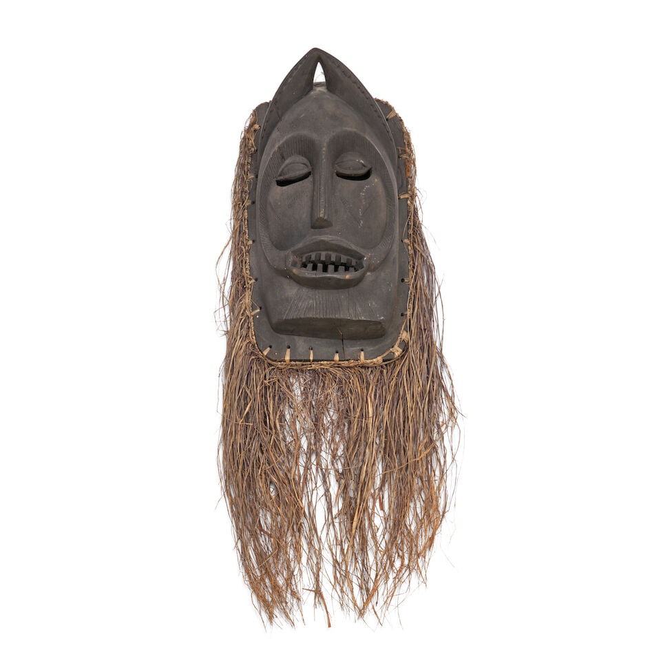 Ibibio Carved Wood Mask, Nigeria,: Ibibio Carved Wood Mask, Nigeria, Carved with an elongated oval face, narrow nose, slit eyes beneath arched brows, and an open mouth inset with carved teeth, lg. 16 3/4 in. (excluding beard). Lot to b