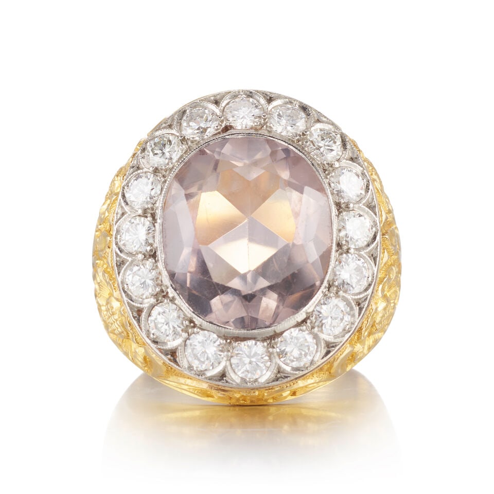 A KUNZITE AND DIAMOND RING: A KUNZITE AND DIAMOND RING • Platinum and 18K yellow gold • One oval shaped kunzite weighing approximately 9.20 carats • Sixteen round shaped diamonds weighing approximately 1.60
