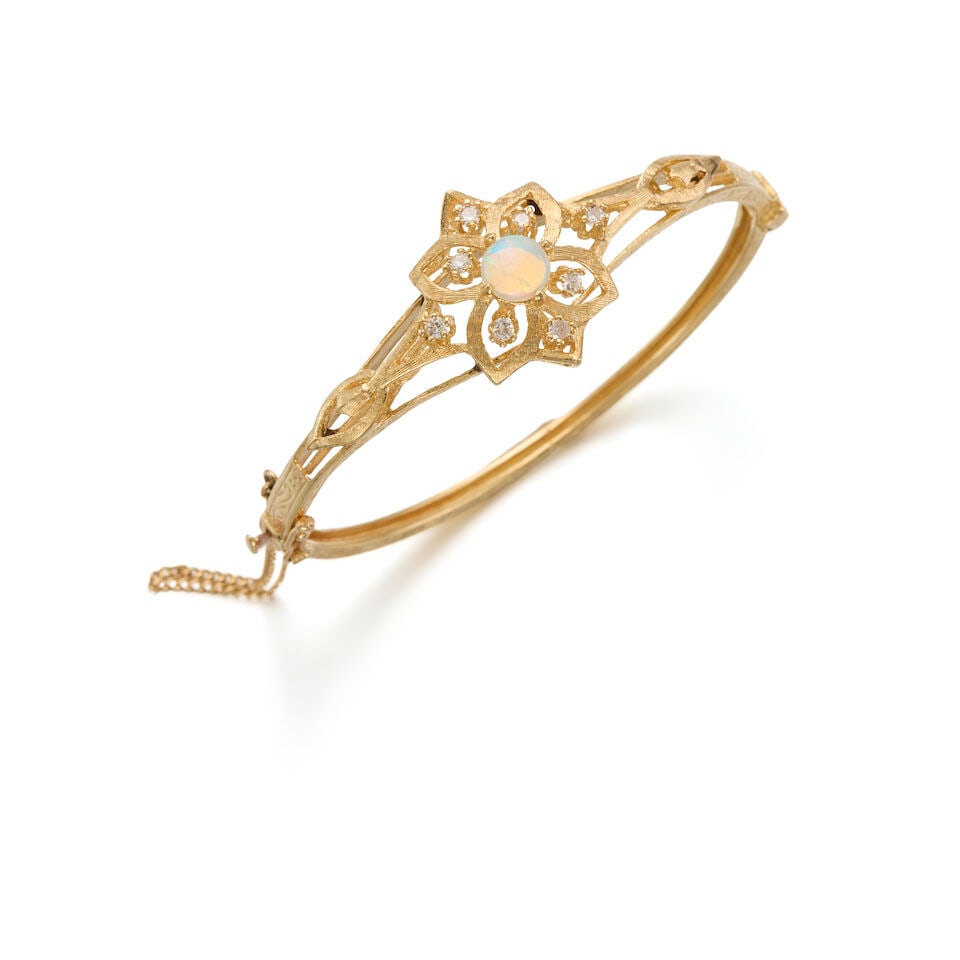 14K YELLOW GOLD, OPAL, AND DIAMOND BANGLE: 14K YELLOW GOLD, OPAL, AND DIAMOND BANGLE • One round shaped opal cabochon measuring approximately 7.40mm x 2.20mm • Eight round shaped diamonds weighing approximately 0.16 carat total 