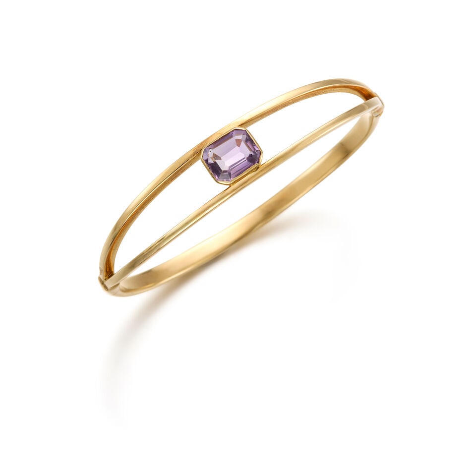A 14K YELLOW GOLD AND AMETHYST BANGLE: A 14K YELLOW GOLD AND AMETHYST BANGLE • A rectangular shaped amethyst weighing approximately 2.20 carats total • Inner circumference 6 3/4 in. • Estimated gross weight: 10.3