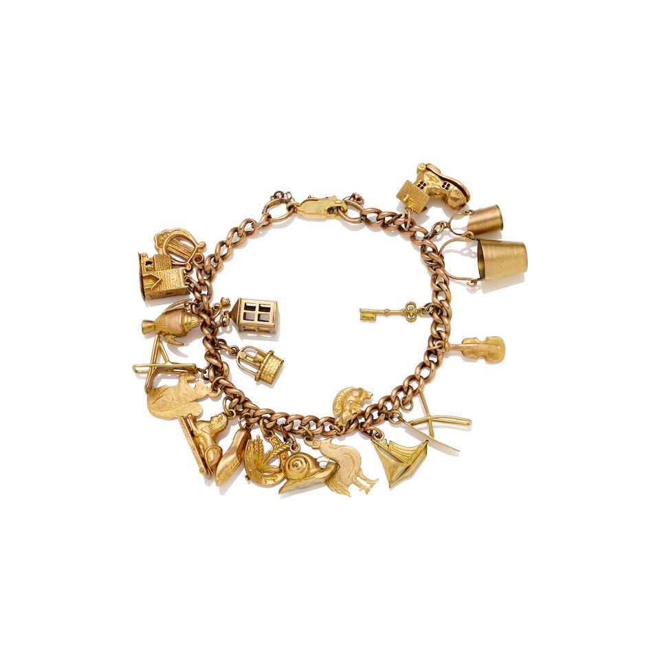 GOLD CHARM BRACELET: GOLD CHARM BRACELET - Curb link bracelet with 14k yellow gold parrot clasp. - Suspending a collection of 375/9k stamped charms - Gross weight approximately 29gm - Full length approximately