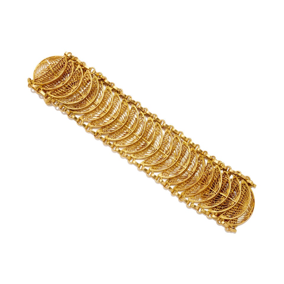 GOLD FILIGREE BRACELET: GOLD FILIGREE BRACELET Articulated gold filigree bracelet, composed of intricate openwork fan-shaped links, fitted with a push piece box clasp and safety chain, weight 46.8gm, length