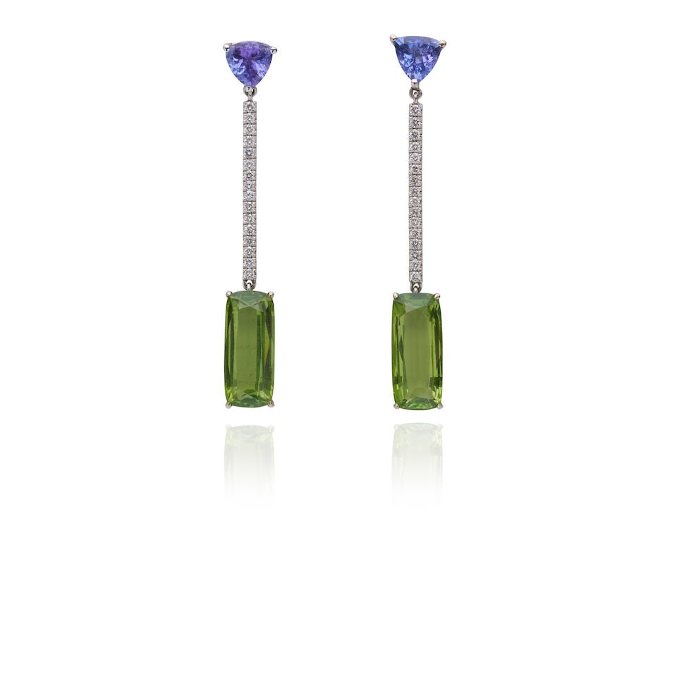 LA JOIE TANZANITE, PERIDOT AND DIAMOND DROP EARRINGS: LA JOIE TANZANITE, PERIDOT AND DIAMOND DROP EARRINGS Trillion-cut Tanzanite surmount, to a line of round brilliant cut diamonds, suspending an elongated cushion-cut yellowish-green tourmaline.