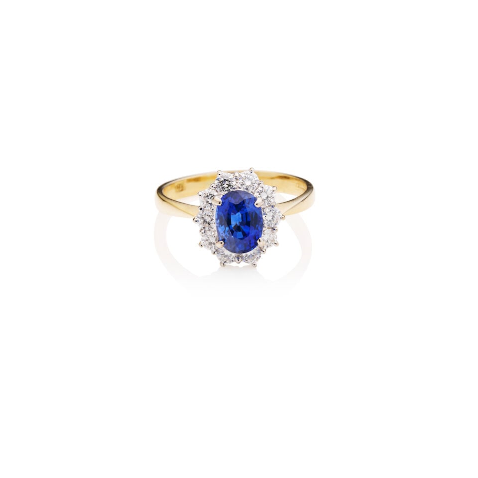 SAPPHIRE AND DIAMOND CLUSTER RING: SAPPHIRE AND DIAMOND CLUSTER RING The oval shaped sapphire with estimated weight 2.2ct, within a halo of round brilliant-cut diamonds, estimated total diamond weight 0.70cts, mounted in yellow and