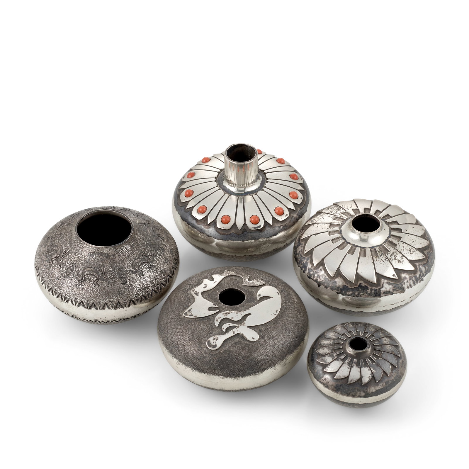 Five Norbert Peshlakai petite silver jars or pots: Norbert Peshlakai Diné (Navajo), (b. 1953), two worked in a repeat eagle feather pattern; a vase with tail feather motif set with a dozen coral spheres; a jar with rabbits above the shoulder and 