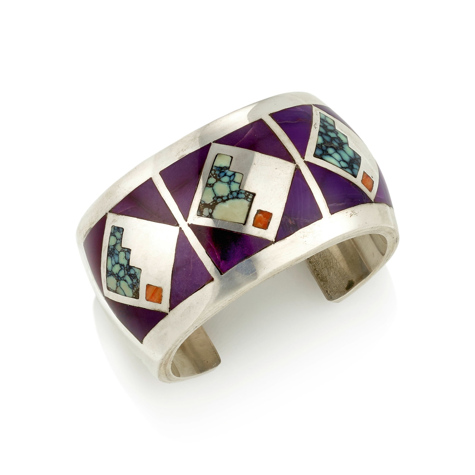 A Danny Romero silver and multi-stone mosaic cuff bracelet: Danny Romero Yaqui/Spanish, (1954-2018), a silver cuff bracelet, designed with three panels of geometric inlay in sugilite, spiny oyster and other materials, with stamped radiating adornment verso and