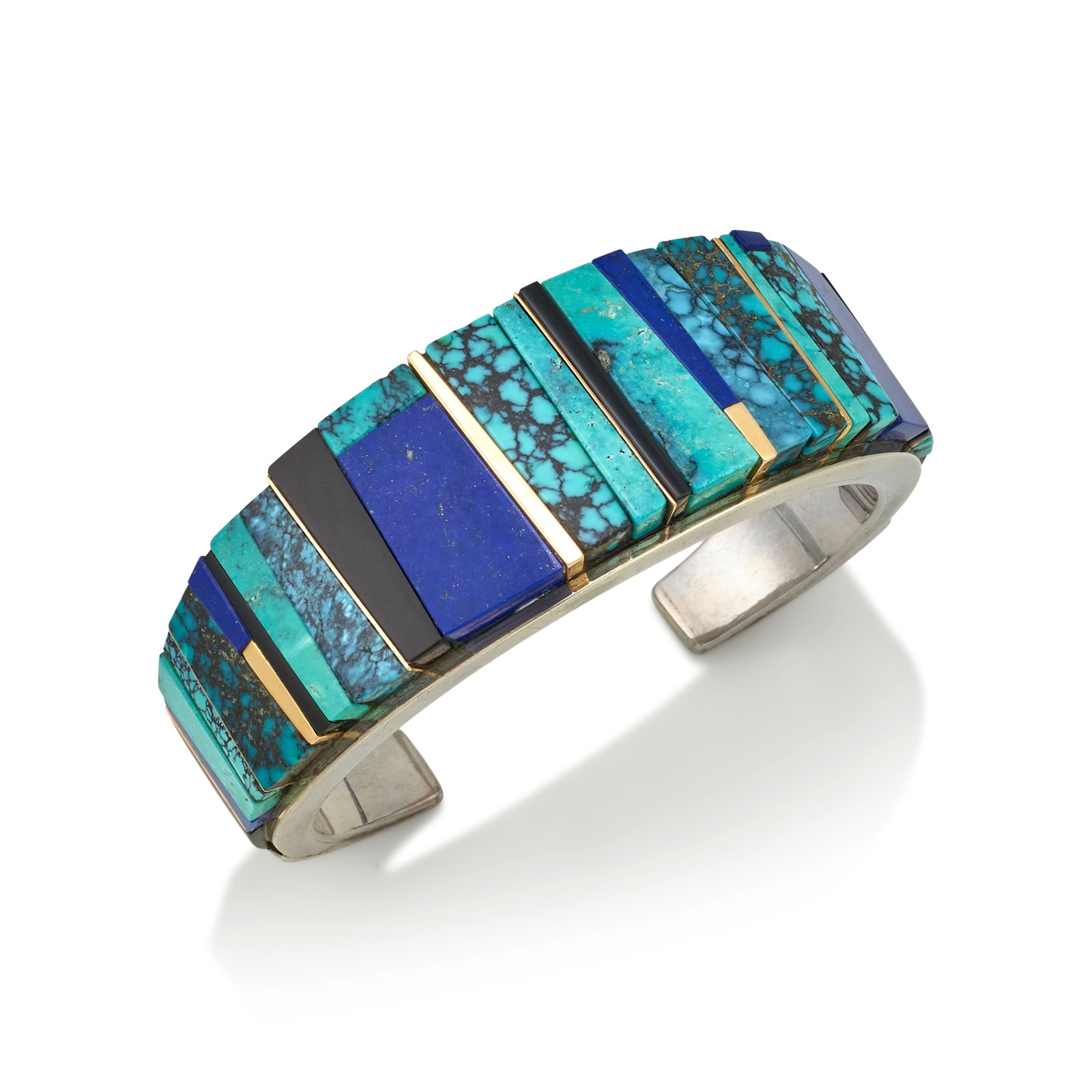 A Luis Mojica silver and multi-stone bracelet: Luis Mojica New Mexican, (20th/21st century), a sterling silver cuff bracelet of tapering form, set with turquoise, lapis and black jade, gold spacers, stamped on the interior with copyright symbol an