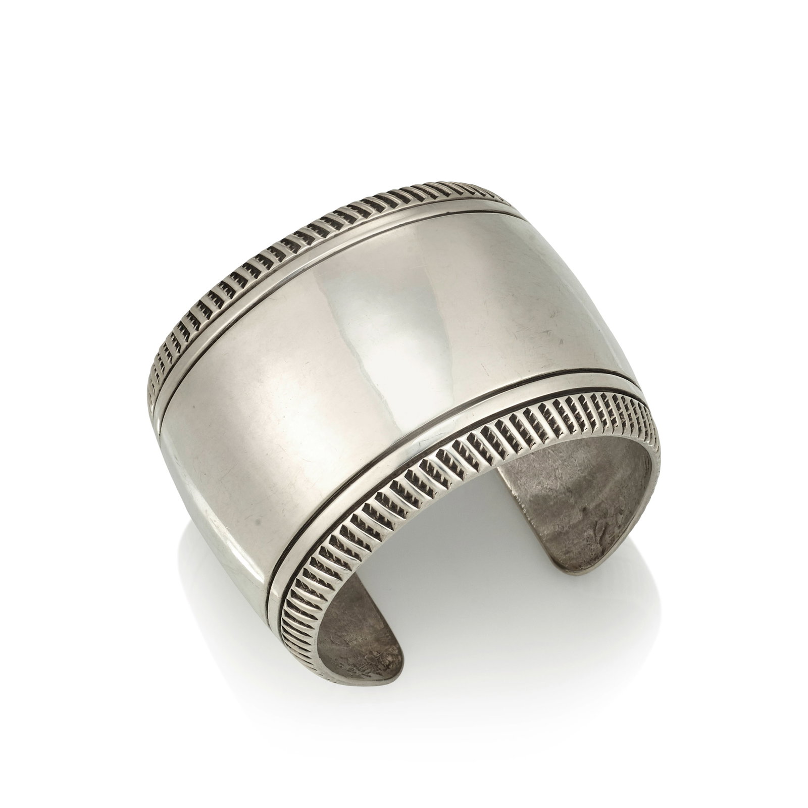 A Cipriano Quintana (Cippy Crazy Horse) sterling silver cuff bracelet: Cipriano Quintana (Cippy Crazy Horse) Cochiti, (b. 1946), a sterling silver cuff bracelet with stamped exterior borders, stamped on the interior: CZH / Sterling. inner circumference (including gap) 6 