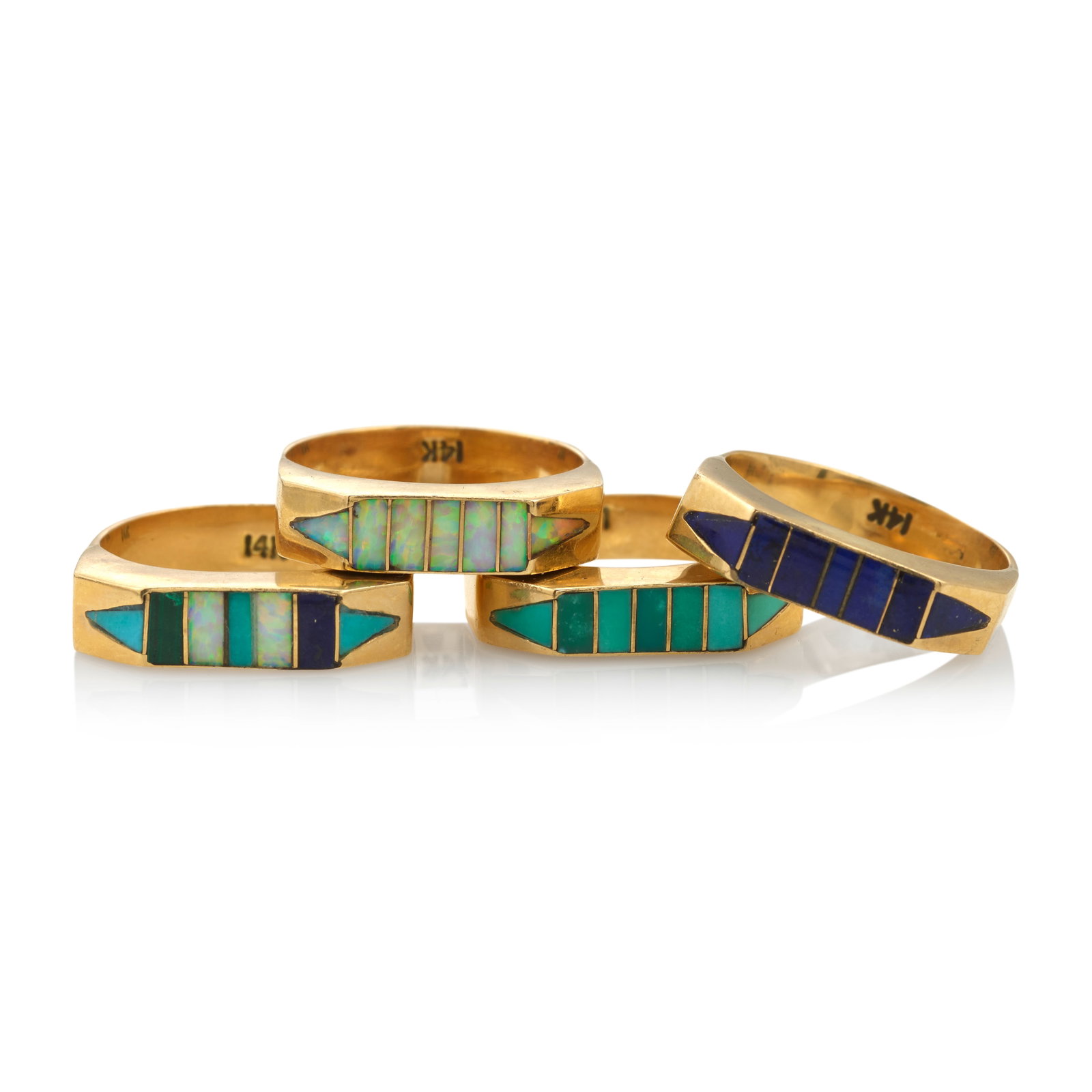 A stacking set of 14k gold gem-set Southwestern style rings: A stacking set of 14k gold gem-set Southwestern style rings Channel set in various combinations of turquoise, lapis and opal, each marked 14k, unsigned for maker. each size approximately 7; gross weig