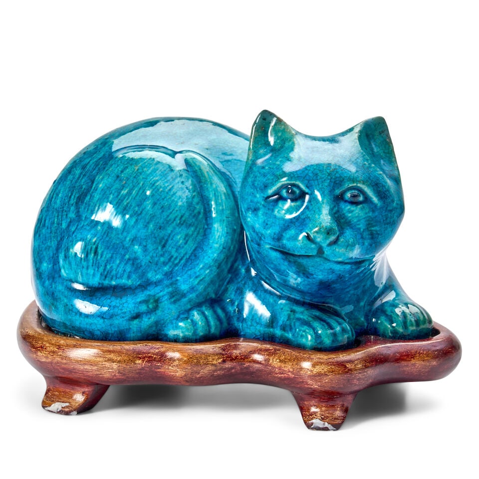 A Turquoise Porcelain Model of a Cat China, Qing Dynasty: A Turquoise Porcelain Model of a Cat China, Qing Dynasty In crouched position with alert expression, its tail coiled around its back haunch, covered with a turquoise glaze to give the effect of natura