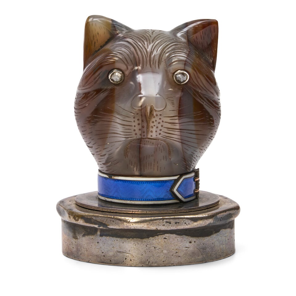 A Carved Agate Model of a Cat's Head, in the Style of Fabergé 20th century: A Carved Agate Model of a Cat's Head, in the Style of Fabergé 20th century With rose-cut diamond eyes, the neck with a gold-mounted blue and white guilloche enamel collar with rose cut diamond bu