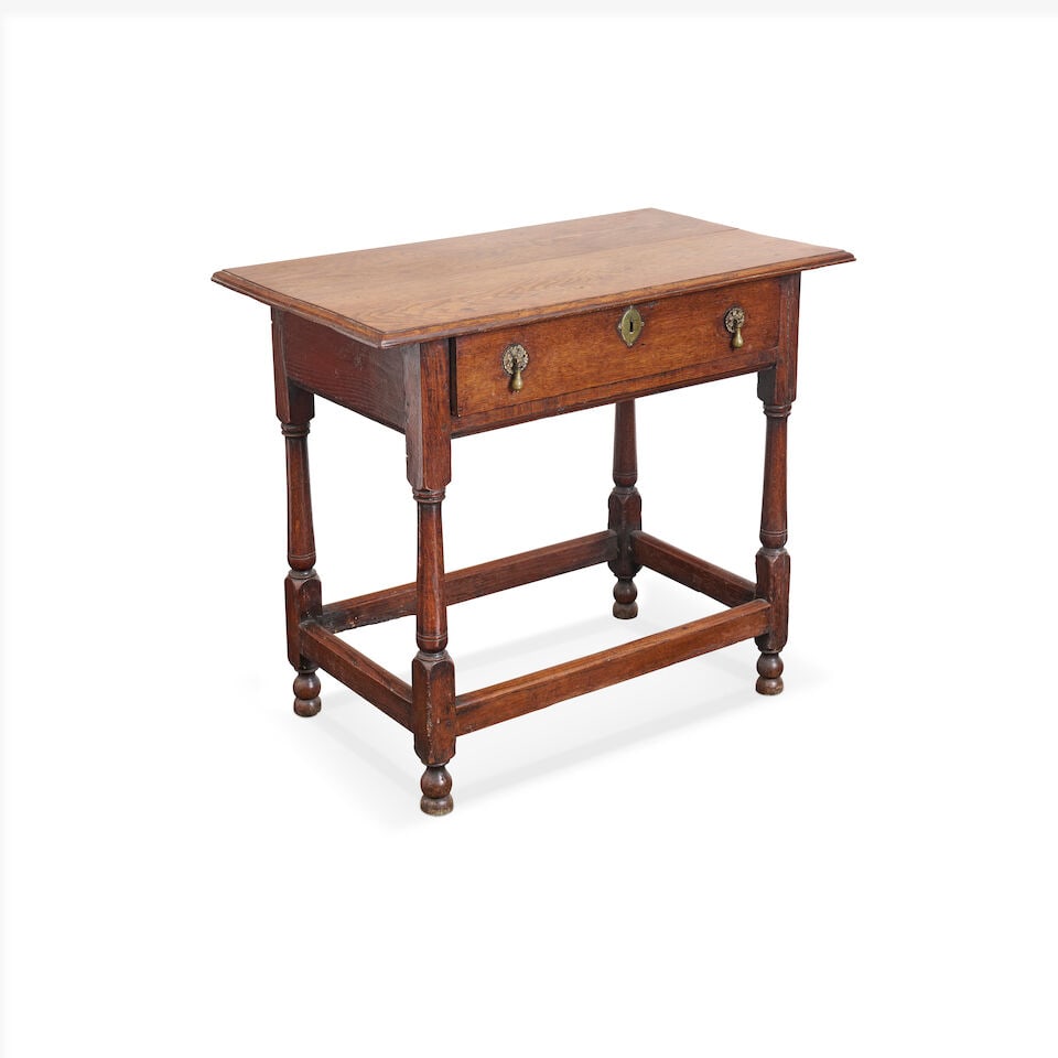 An English oak side table, early 18th century,: An English oak side table, early 18th century, with a well figured rectangular moulded oak top, above a single frieze drawer, raised on turned legs with peripheral stretcher, height: 70.0cm, width: 82
