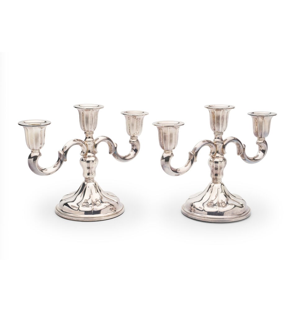 A pair of Scandanavian silver three-branch candelabra: A pair of Scandanavian silver three-branch candelabra purity .830, total weight 1475 grams (both bases weighted with plaster) For further information on this lot please visit Bonhams.com For further