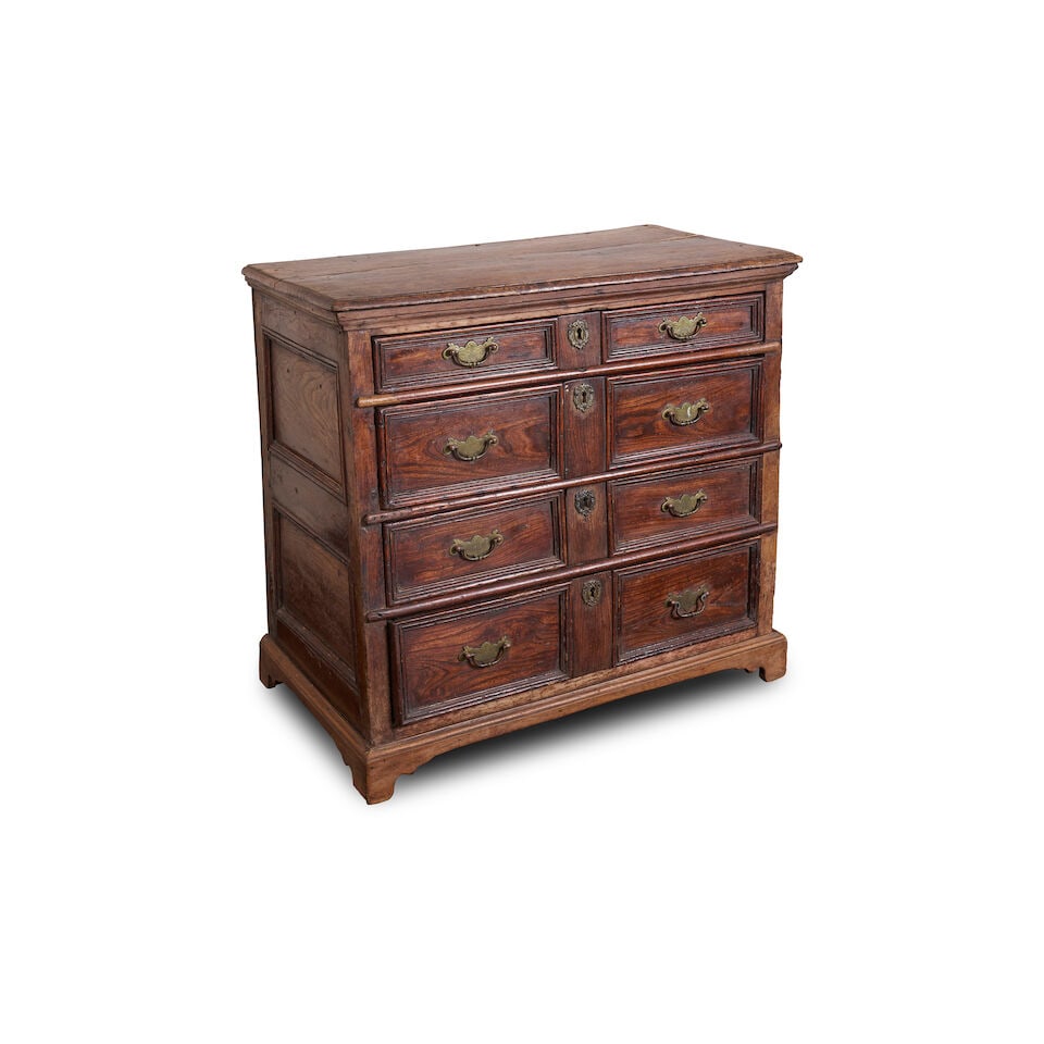 An English elm chest of drawers, late 17th/ early 18th century,: An English elm chest of drawers, late 17th/ early 18th century, with moulded top above four long drawers, on later applied bracket feet and moulding, overall height: 88.0cm, width: 94.0cm, depth: