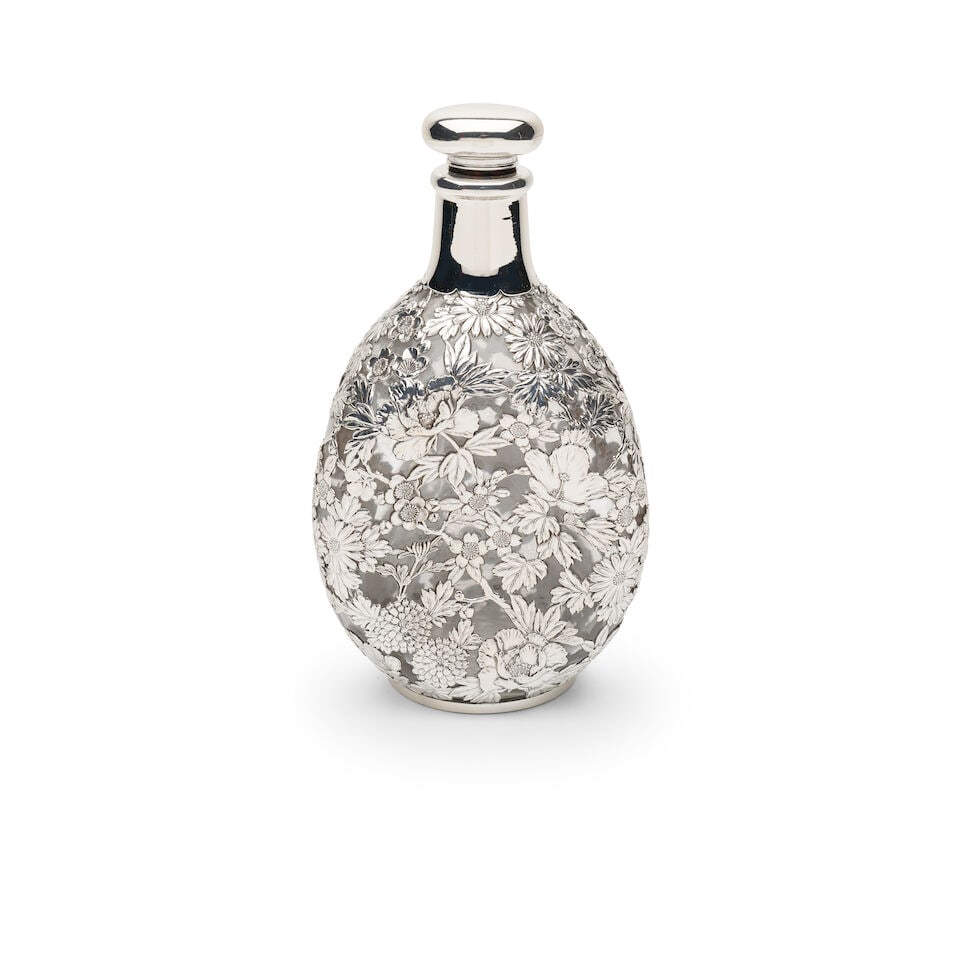 A Japanese silver-mounted whiskey decanter and stopper: A Japanese silver-mounted whiskey decanter and stopper 925 marks, in the form of a Dimple Haig bottle, 23cm high, weight total 714 grams For further information on this lot please visit