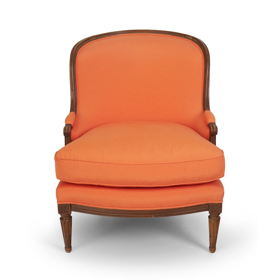 A French beech Louis XVI style bergere,: A French beech Louis XVI style bergere, curved back, supported on tapering fluted legs, with later linen upholstery, and loose seat cushion, overall height: 95.0cm, width: 77.0cm, depth: 83.0cm For