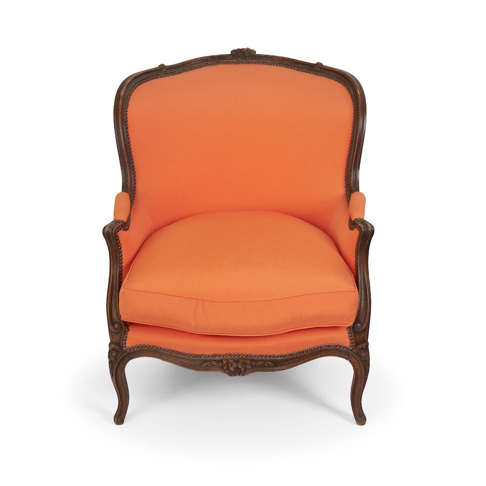 A French beech Louis XV style bergere,: A French beech Louis XV style bergere, curved back with foliate crest rail carving, supported on cabriole legs, with later linen upholstery, and loose seat cushion, overall height: 96.0cm, width: