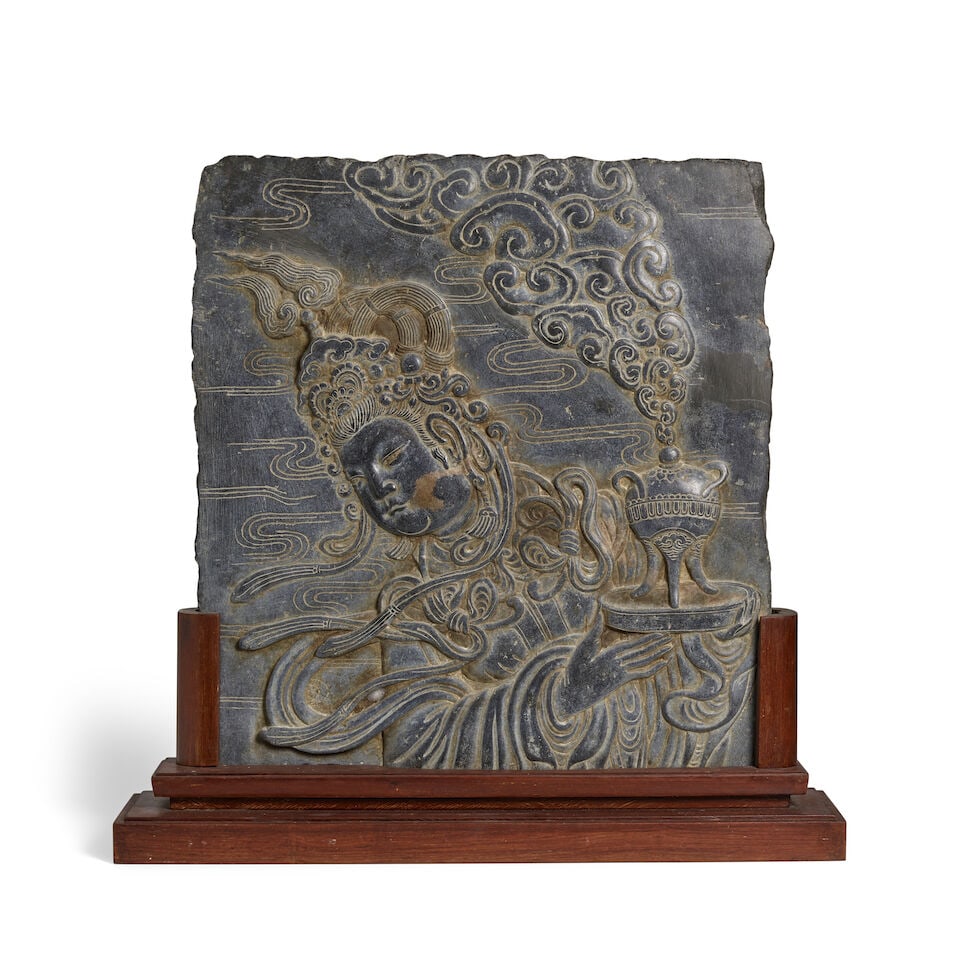 A LIMESTONE CARVING OF A CELESTIAL ATTENDANT Early 20th century (fitted wood stand): A LIMESTONE CARVING OF A CELESTIAL ATTENDANT Early 20th century 23 3/4 x 22in (60.3 x 56cm) (fitted wood stand). Footnotes: 二十世紀初 石灰岩浮