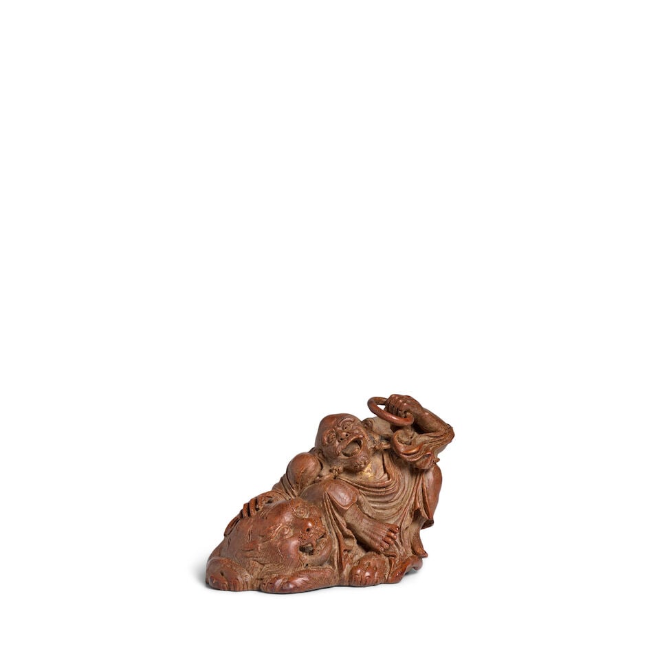 A BAMBOO-ROOT 'LUOHAN AND TIGER' CARVING 18th century: A BAMBOO-ROOT 'LUOHAN AND TIGER' CARVING 18th century 6 1/4in (16cm) long Footnotes: 十八世紀 竹根雕伏虎羅漢擺件 For