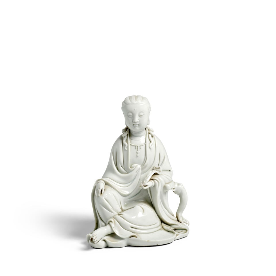 A DEHUA WHITE-GLAZED SEATED FIGURE OF GUANYIN 20th century: A DEHUA WHITE-GLAZED SEATED FIGURE OF GUANYIN 20th century The backside with an incised four-character Daqing Nianzhi mark. 7 1/2in (19cm) high Footnotes: 二十世紀 「