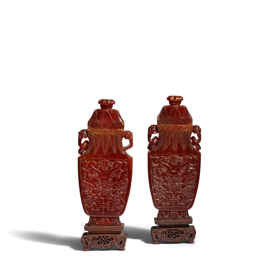 A PAIR OF CARVED AMBER 'TAOTIE MASK' VASES AND COVERS Qianlong/Jiaqing period (2, wood stands an...: A PAIR OF CARVED AMBER 'TAOTIE MASK' VASES AND COVERS Qianlong/Jiaqing period 8 7/8in (22.5cm high) each (2, wood stands and boxes). Footnotes: 清乾隆/嘉慶 琥ஓ