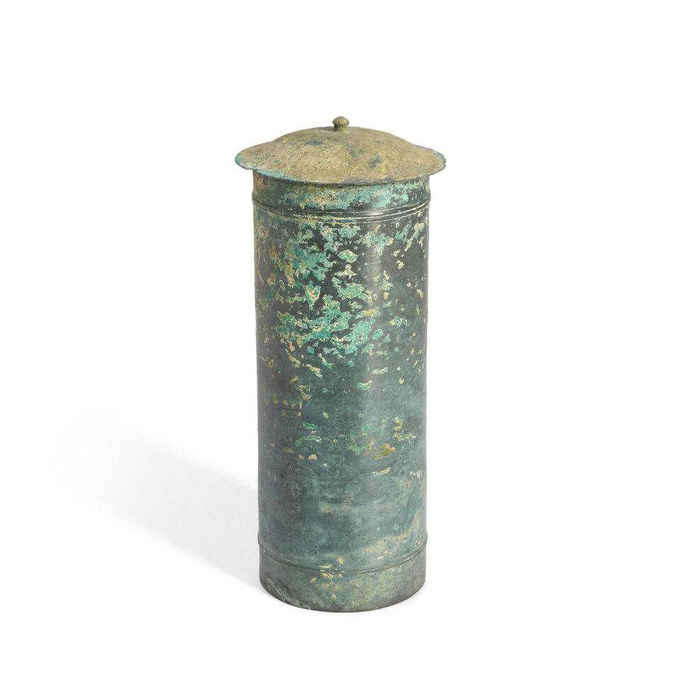 A Copper Sutra Box and Cover Japan, possibly Heian period (794-1185), 12th century,: A Copper Sutra Box and Cover Japan, possibly Heian period (794-1185), 12th century, Cylindrical, the lid surmounted by a small finial 10 3/4in (27.4)cm high overall For further information on this lot