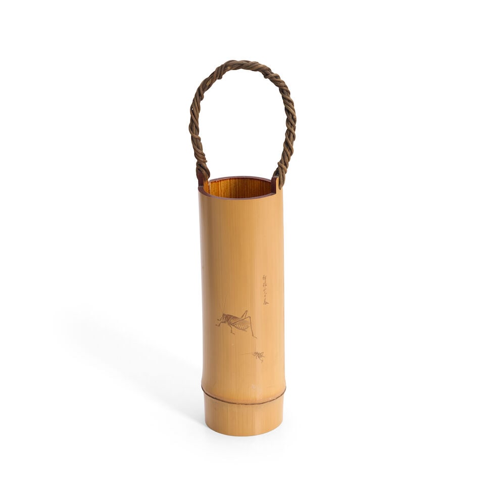 A Bamboo Container Japan, Taisho (1912-1926) or Showa (1926-1989) era, 20th century,: A Bamboo Container Japan, Taisho (1912-1926) or Showa (1926-1989) era, 20th century, Natural bamboo form, incised with grasshoppers, with a woven wicker handle, signed 15 1/4in (38.7cm) high For