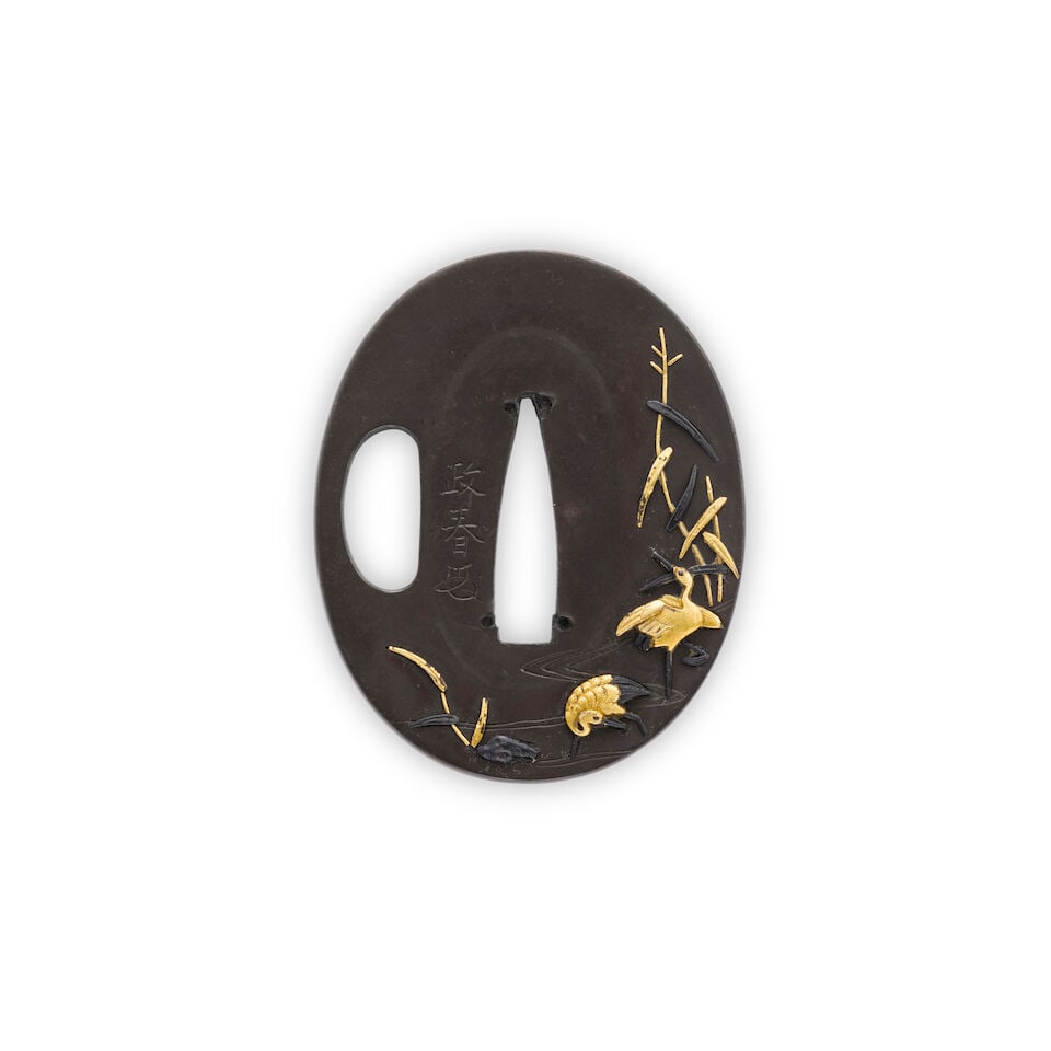 An Oval Shibuichi Tsuba Japan, Edo period (1615-1868), 19th century,: An Oval Shibuichi Tsuba Japan, Edo period (1615-1868), 19th century, The small tanto tsuba decorated with herons in a stream with rocks and reeds, signed Masaharu and with the artist's kao With a wood