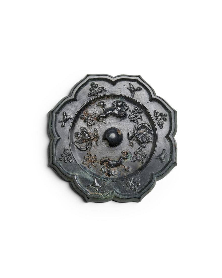 A Silvered Bronze 'Lion and Phoenix' Foliate-Rimmed Mirror Tang dynasty style, 20th century,: A Silvered Bronze 'Lion and Phoenix' Foliate-Rimmed Mirror Tang dynasty style, 20th century, A central knob surrounded by lions alternating with phoenixes within an eight-petal rim 6 1/4in (15.9cm) di