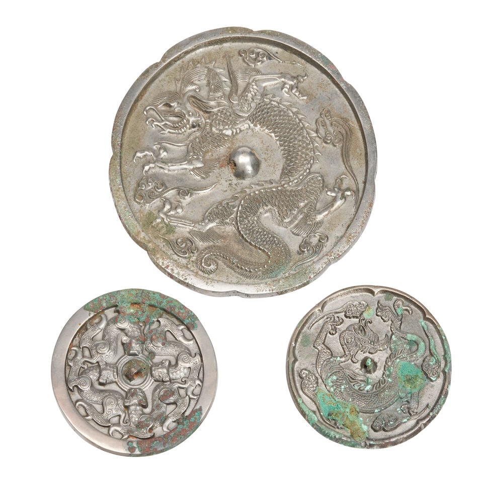 Three Bronze Mirrors Cast with Dragons China, Tang dynasty style, 20th century, (3): Three Bronze Mirrors Cast with Dragons China, Tang dynasty style, 20th century, A large mirror with a lobed rim and coiled dragon; a smaller lobed mirror; and a round mirror with four chilong 5in (12.