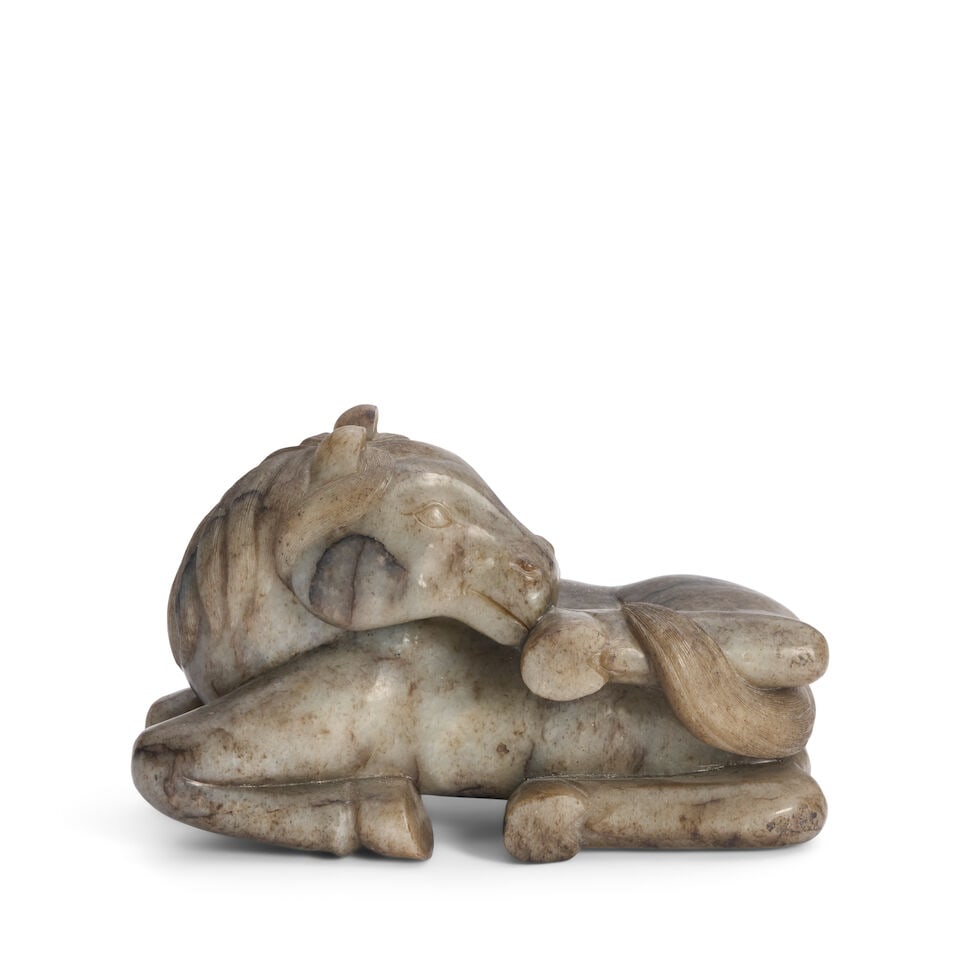 A Large Gray-green Jade Carving of a Recumbent Horse China, 20th century,: A Large Gray-green Jade Carving of a Recumbent Horse China, 20th century, 9in long (22.9cm) Footnotes: Provenance: Property from the Collection of Alan and Simone Hartman This lot is subject to the fo