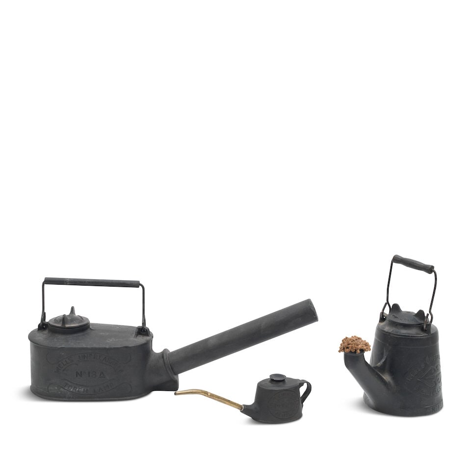 Two different model Wells 'Unbreakable' Kettle Torch Lamps by A. O. Wells & Co, ((3)): Two different model Wells 'Unbreakable' Kettle Torch Lamps by A. O. Wells & Co, each heavy cast iron, comprising model No.18A with lid and bail handle, 51cm long and model No. 18 with lid, (one fittin