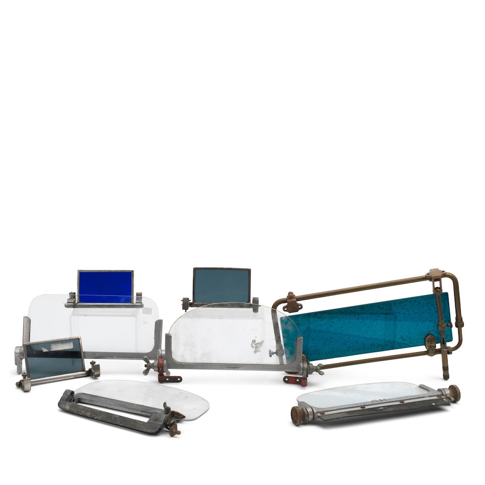A Brooklands aero screen, and other vintage screens, ((8)): A Brooklands aero screen, and other vintage screens, the Brooklands screen with nickelled mount, brackets and fittings, with Perspex screen 30cm wide; together with three other Perspex screens, one
