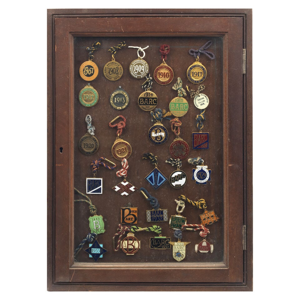 A framed display of BARC Brooklands Members' lapel badges 1907-1916 and 1920-1939, ((Qty)): A framed display of BARC Brooklands Members' lapel badges 1907-1916 and 1920-1939, most in coloured enamels, 1916 in printed Ivoreen, some with original cords, (others lacking or with replaced cords),