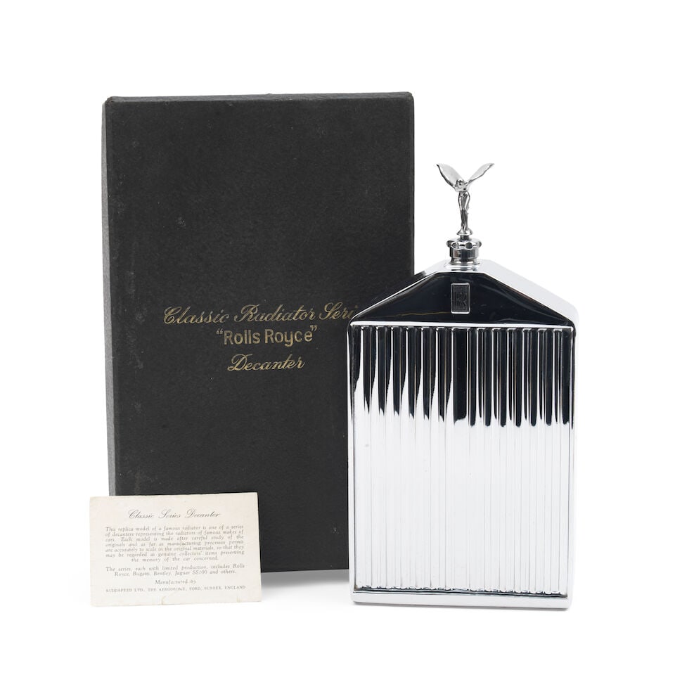 A boxed Rolls-Royce radiator decanter by Ruddspeed, ((3)): A boxed Rolls-Royce radiator decanter by Ruddspeed, chromed with shutters, badge, and miniature 'Spirit of Ecstasy' plastic mascot, 24cm high overall, contained in original blue satin lined box (some 