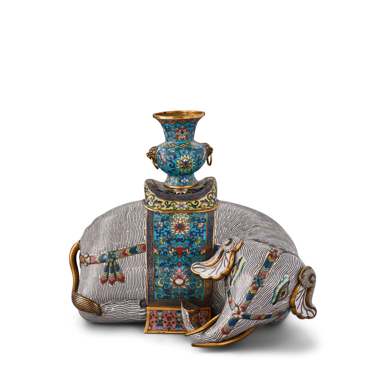 A CLOISONNÉ ENAMEL FIGURE OF A RECUMBENT ELEPHANT 19th century: A CLOISONNÉ ENAMEL FIGURE OF A RECUMBENT ELEPHANT 19th century The caparisoned elephant neatly decorated in white-ground cloisonné, its head sharply turned to one side wearing beaded and jew