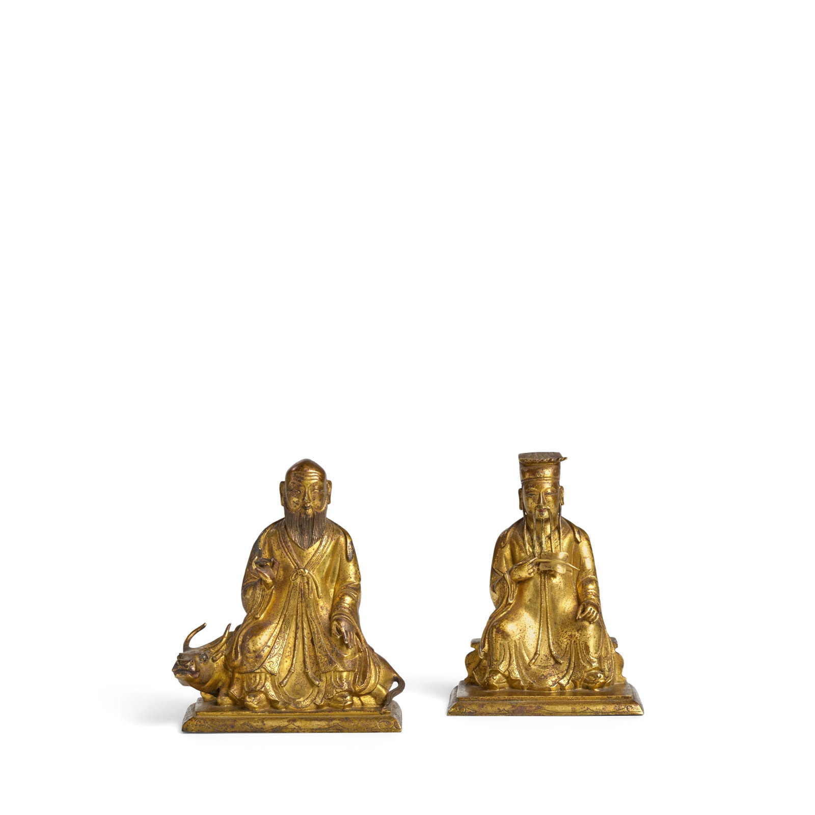 TWO GILT-BRONZE SEATED DAOIST FIGURES 17th/18th century (2): TWO GILT-BRONZE SEATED DAOIST FIGURES 17th/18th century Each exquisitely cast, the first depicting the bearded sage Laozi seated atop a horned buffalo, his domed head modelled with a deeply furrowed b