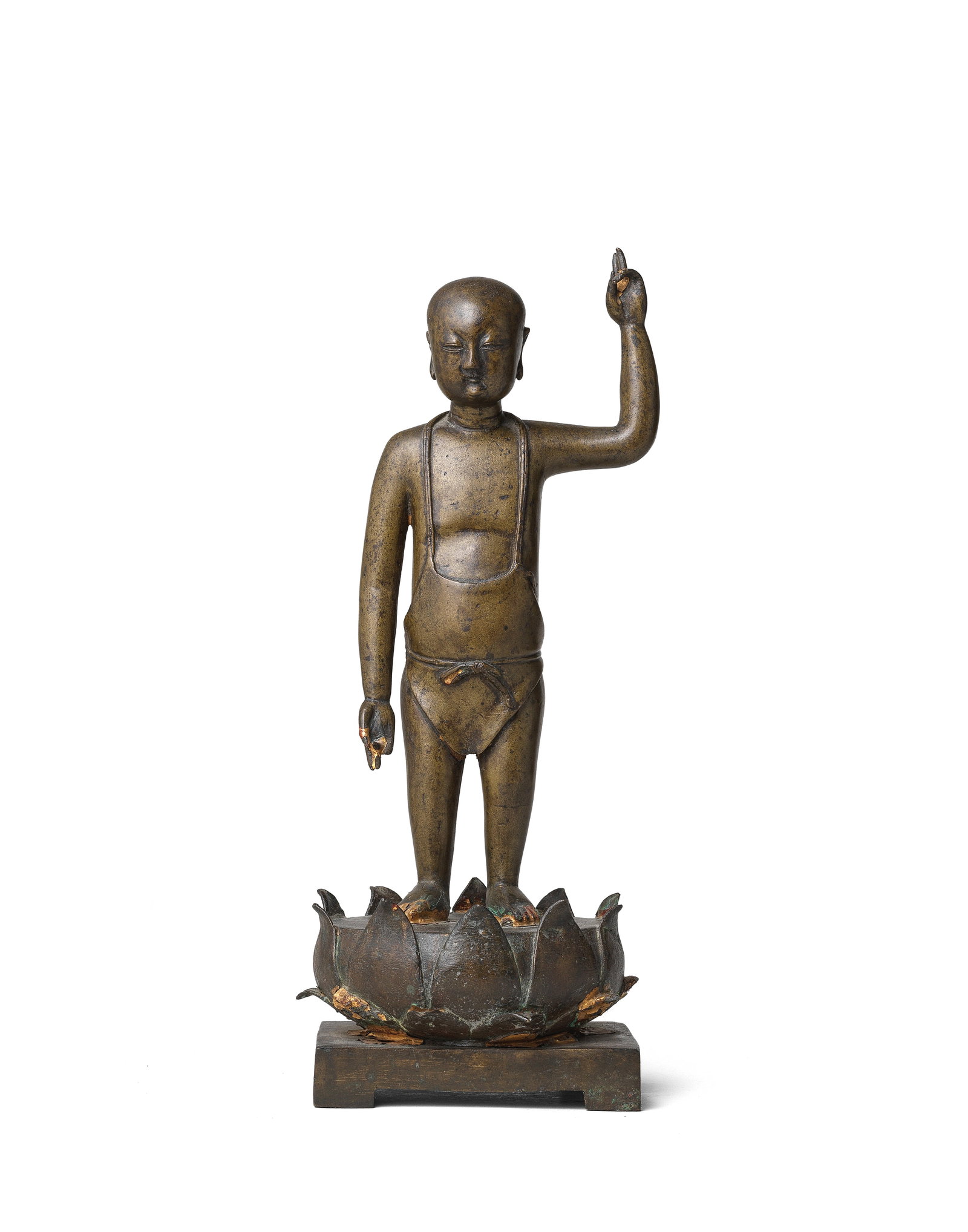 A BRASS FIGURE OF THE INFANT BUDDHA Ming Dynasty: A BRASS FIGURE OF THE INFANT BUDDHA Ming Dynasty Standing on a circular lotus base, his left arm raised to the sky and his right arm extending down pointing at the earth, wearing a diaphanous apron ti