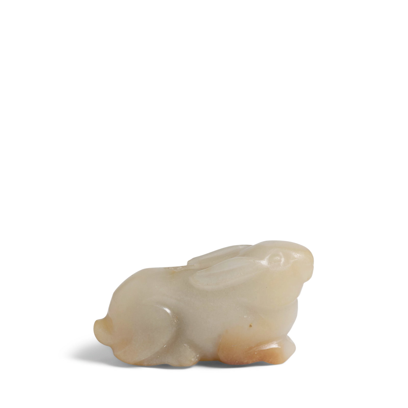 A JADE CARVED 'RABBIT' TOGGLE Song Dynasty: A JADE CARVED 'RABBIT' TOGGLE Song Dynasty Naturalistically modelled with its head raised, its long ears swept backwards, the front paws and the hind legs tucked under the muscular haunches, center of