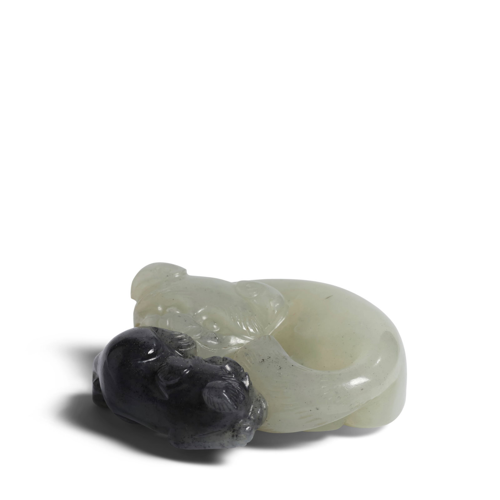 A BLACK AND WHITE JADE 'CATS' GROUP Ming Dynasty (wood stand, Japanese box): A BLACK AND WHITE JADE 'CATS' GROUP Ming Dynasty Carved in the round, the felines in recumbent poses encircling each other, their faces with large round eyes and short snout, the inky part of the ston