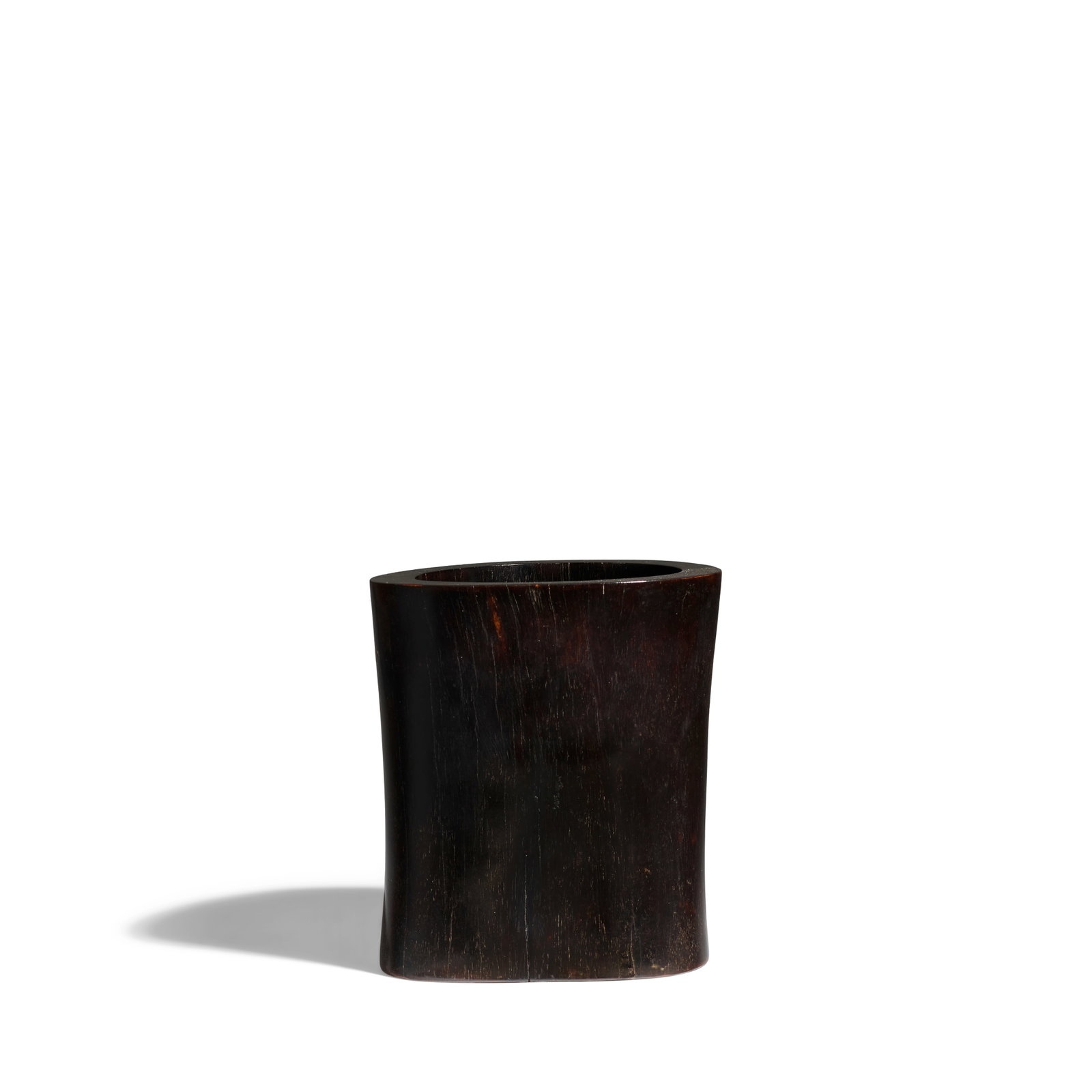 A ZITAN TRUNK-FORM BRUSHPOT 18th century: A ZITAN TRUNK-FORM BRUSHPOT 18th century Following the natural shape of the tree trunk, the base with a circular insert at the center, the very fine and dark wood grain with areas of golden and amber 