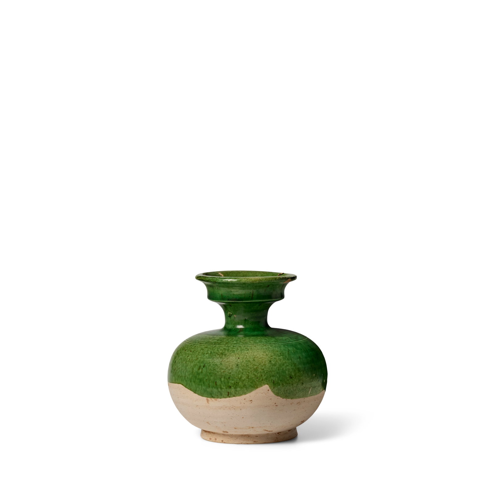 A GREEN AND AMBER-GLAZED POTTERY VASE Tang Dynasty: A GREEN AND AMBER-GLAZED POTTERY VASE Tang Dynasty The compressed spherical body surmounting a small neck with angled mouth, covered with a translucent green glaze half-way down the vessel, a drip of 