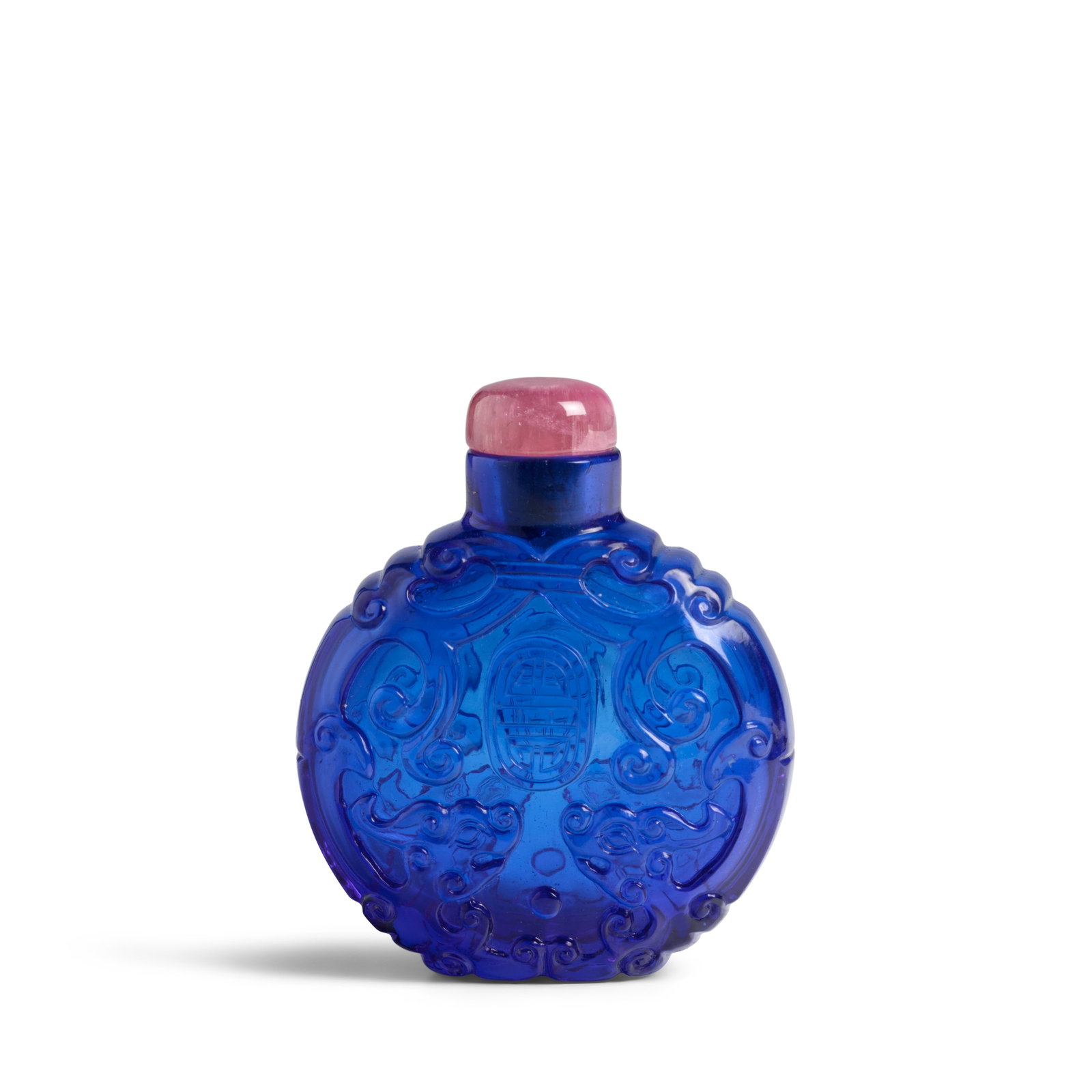 A FINE PEACOCK-BLUE GLASS SNUFF BOTTLE 1820-1880: A FINE PEACOCK-BLUE GLASS SNUFF BOTTLE 1820-1880 Of facetted shield shape and circular neck, flat rim and wide mouth, the elegant bottle finely carved on each face with paired chilong, their bodies an