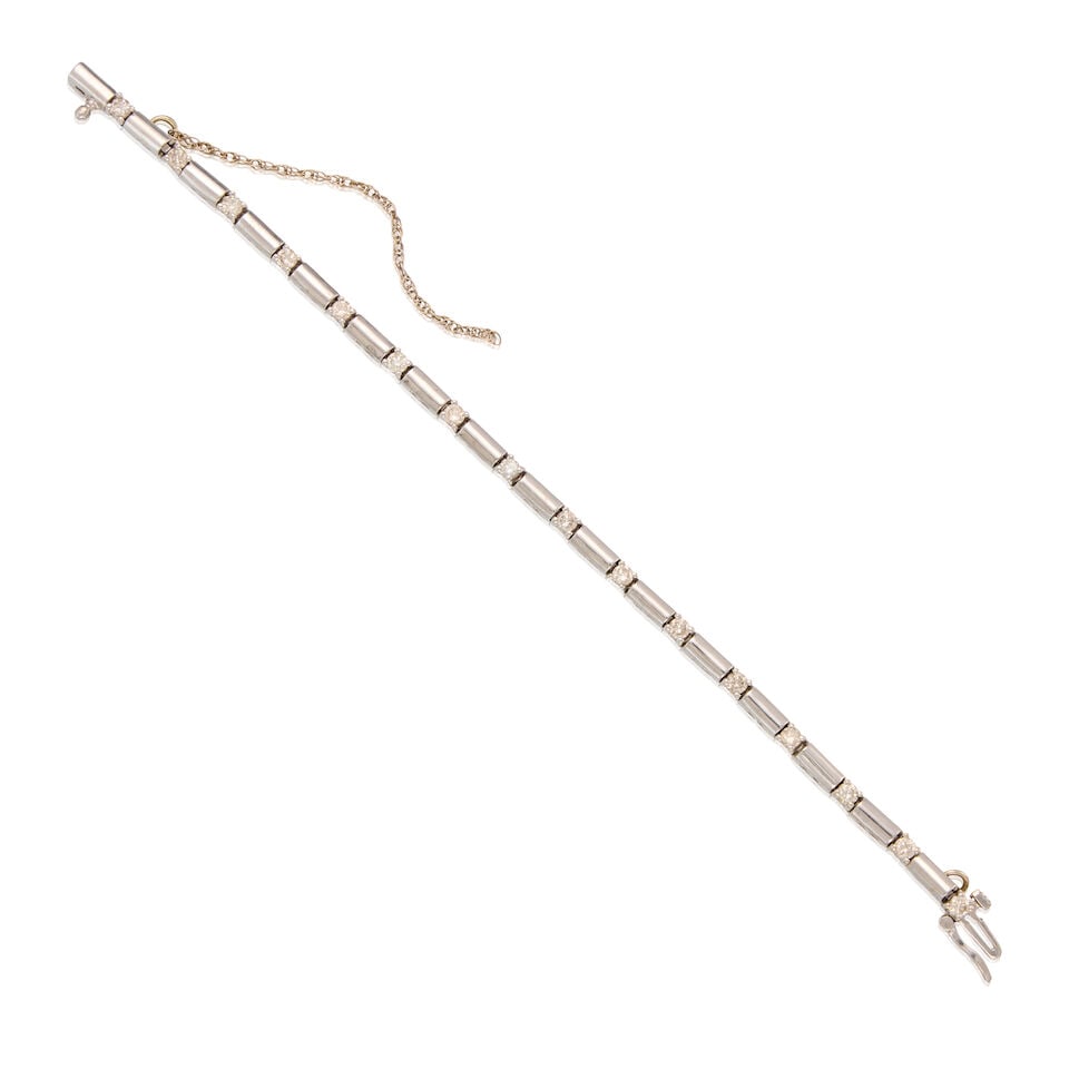 14K WHITE GOLD AND DIAMOND STATION BRACELET: 14K WHITE GOLD AND DIAMOND STATION BRACELET • 14K white gold bracelet with safety chain • Sixteen round brilliant cut diamonds weighing approximately 0.16 carat total • Inner