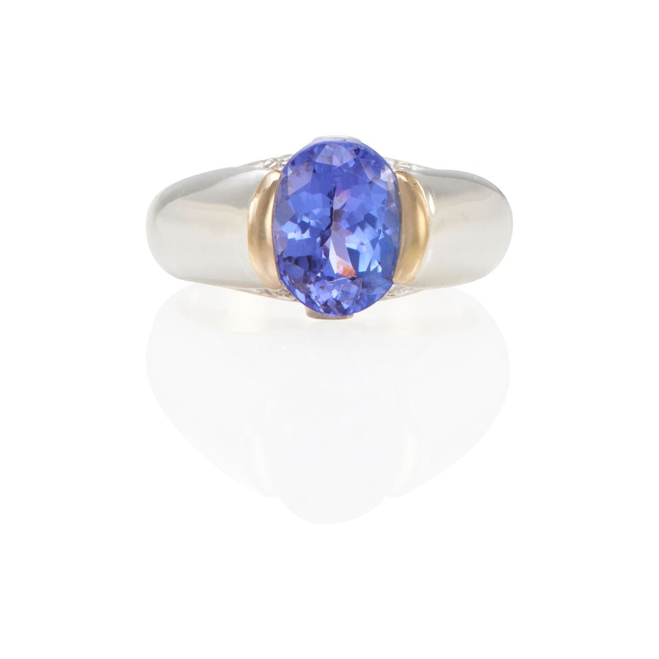 AN 18K WHITE GOLD, DIAMOND, AND TANZANITE RING: AN 18K WHITE GOLD, DIAMOND, AND TANZANITE RING • One oval-shaped tanzanite weighing approximately 2.40 carats total • Sixteen round brilliant-cut diamonds weighing approximately 0.20 -
