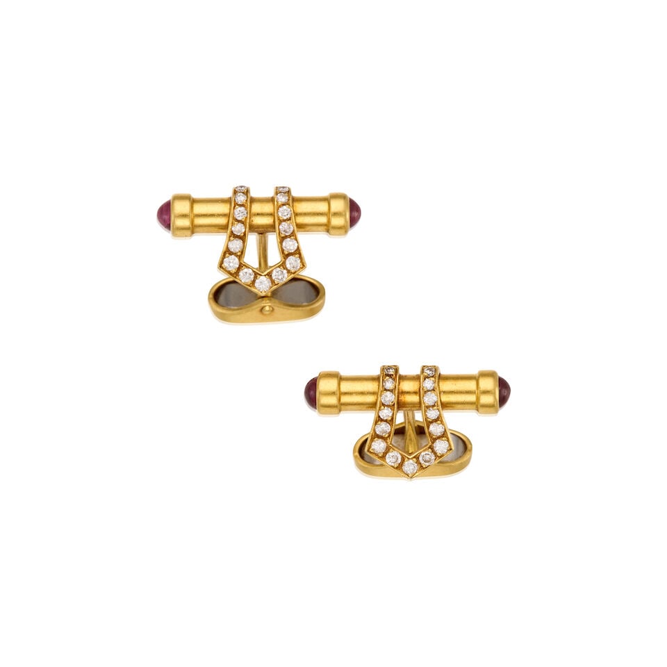 18K GOLD, DIAMOND AND RUBY BUCKLE CUFFLINKS: 18K GOLD, DIAMOND AND RUBY BUCKLE CUFFLINKS • Four round cabochon shaped rubies measuring approximately 3.92mm in diameter • Thirty round brilliant-cut diamonds weighing approximately 0.60